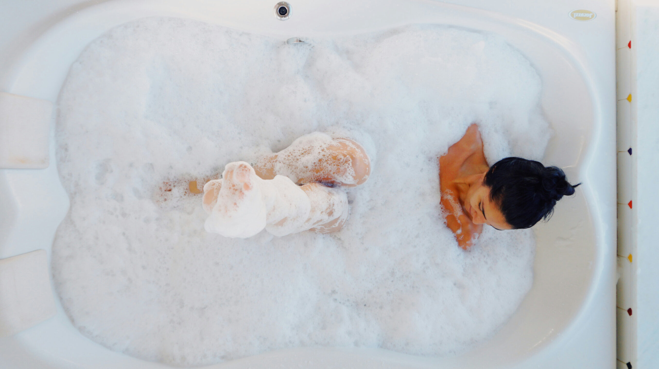 Volle Badewanne mit stehendem Wasser über dem Abfluss